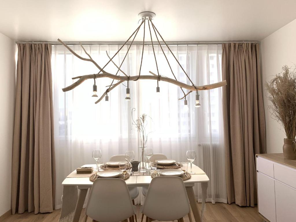 une table à manger avec des chaises et un lustre dans l'établissement apt lumieuse confor parking free, à Paris