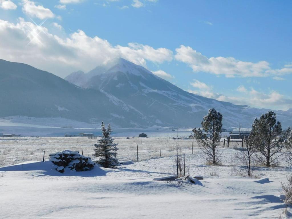 a snow covered field with a mountain in the background at Chico Peak cabin nr Yellowstone,Chico Hot Springs in Pray