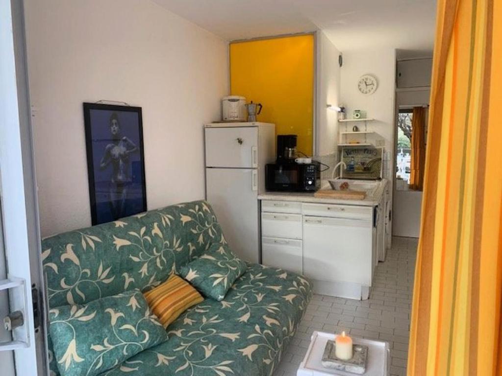 un salon avec un canapé et une cuisine dans l'établissement Résidence Port Nature Colline 2 - Studio- Port Nature Colline 2 - 2 pers. MAE-6641, au Cap d'Agde