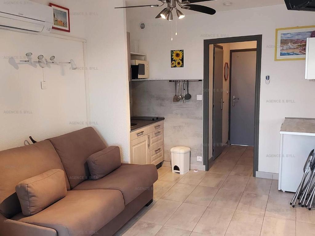 un salon avec un canapé et une cuisine dans l'établissement Résidence Héliopolis Bâtiment Fgh - STUDIO 2 pers. HELIOPOLIS FGH MAE-5271, au Cap d'Agde