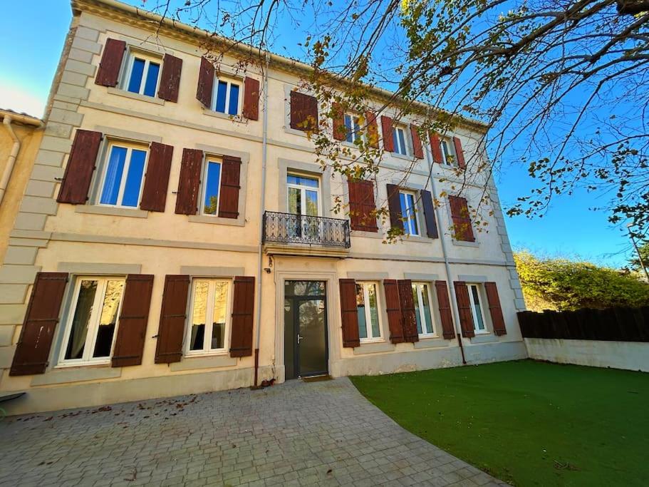 - un grand bâtiment avec une porte devant dans l'établissement La Maison Cardau, à Névian