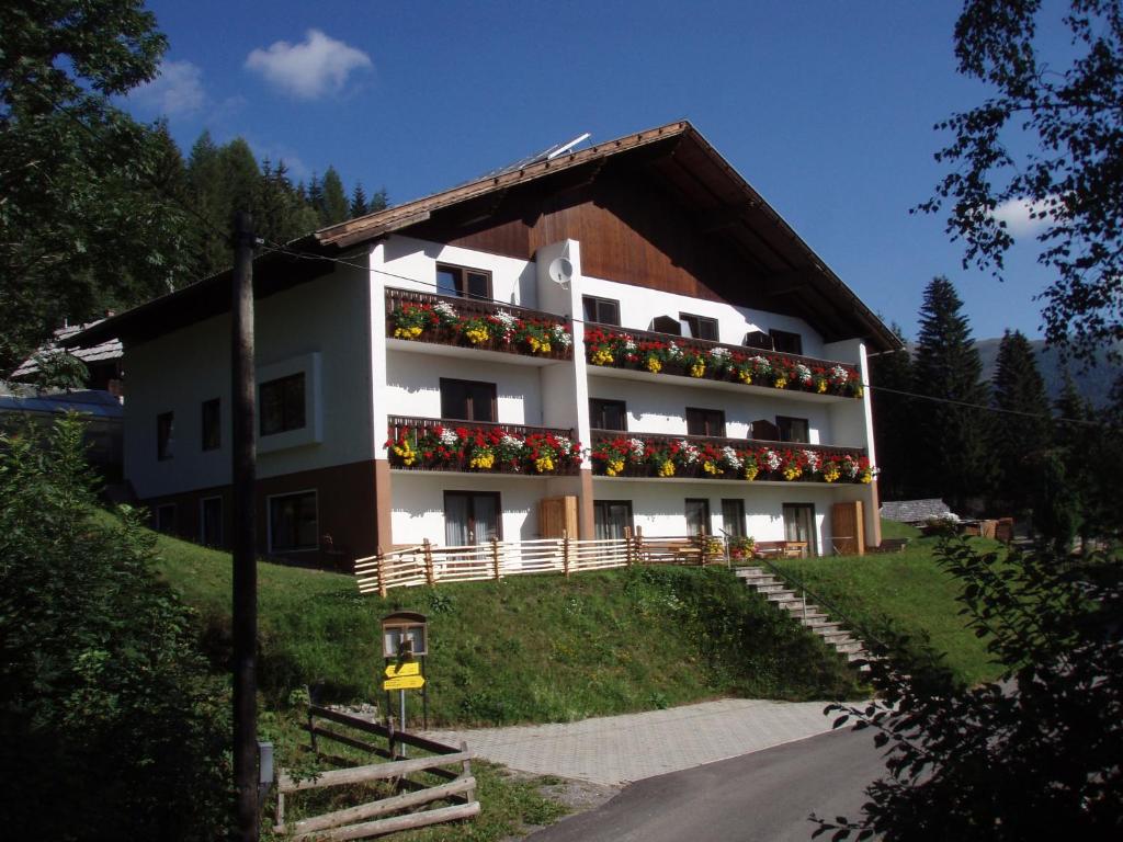 duży biały budynek z kwiatami na balkonie w obiekcie Haus Bergblick w mieście Bad Kleinkirchheim