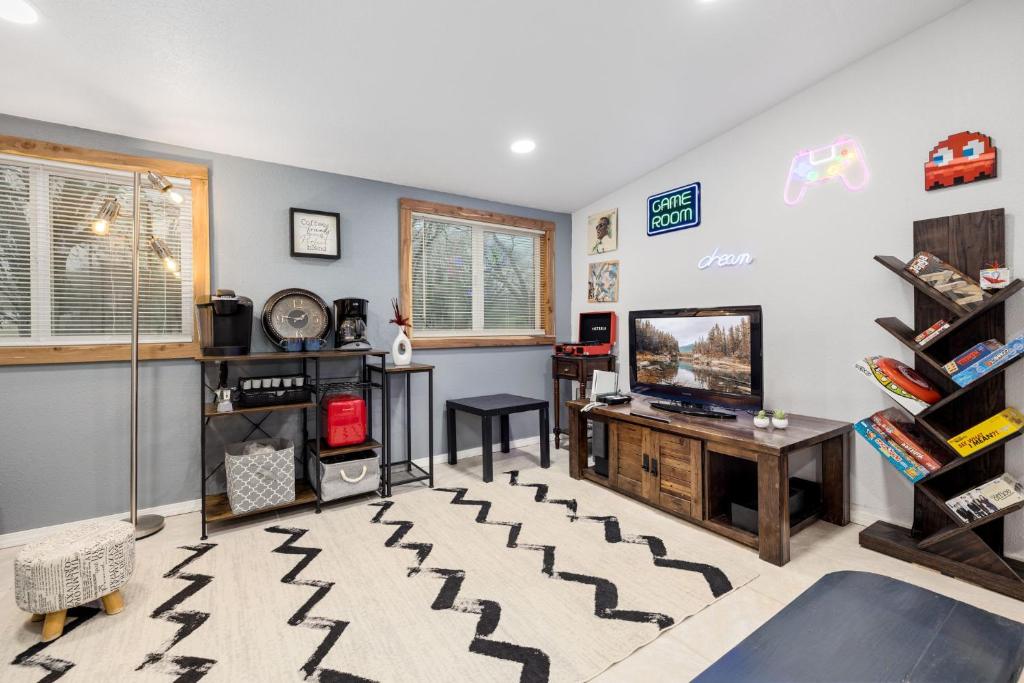 a living room with a tv and a table at Creekside Cabin - Beaver Lake Creek Access in Rogers