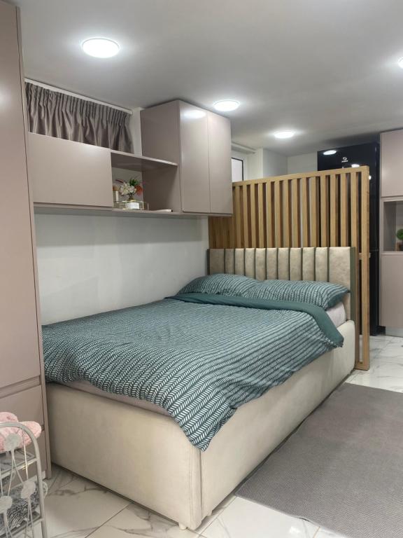 un lit avec une tête de lit en bois dans une chambre dans l'établissement Studio Dijon, à Dijon