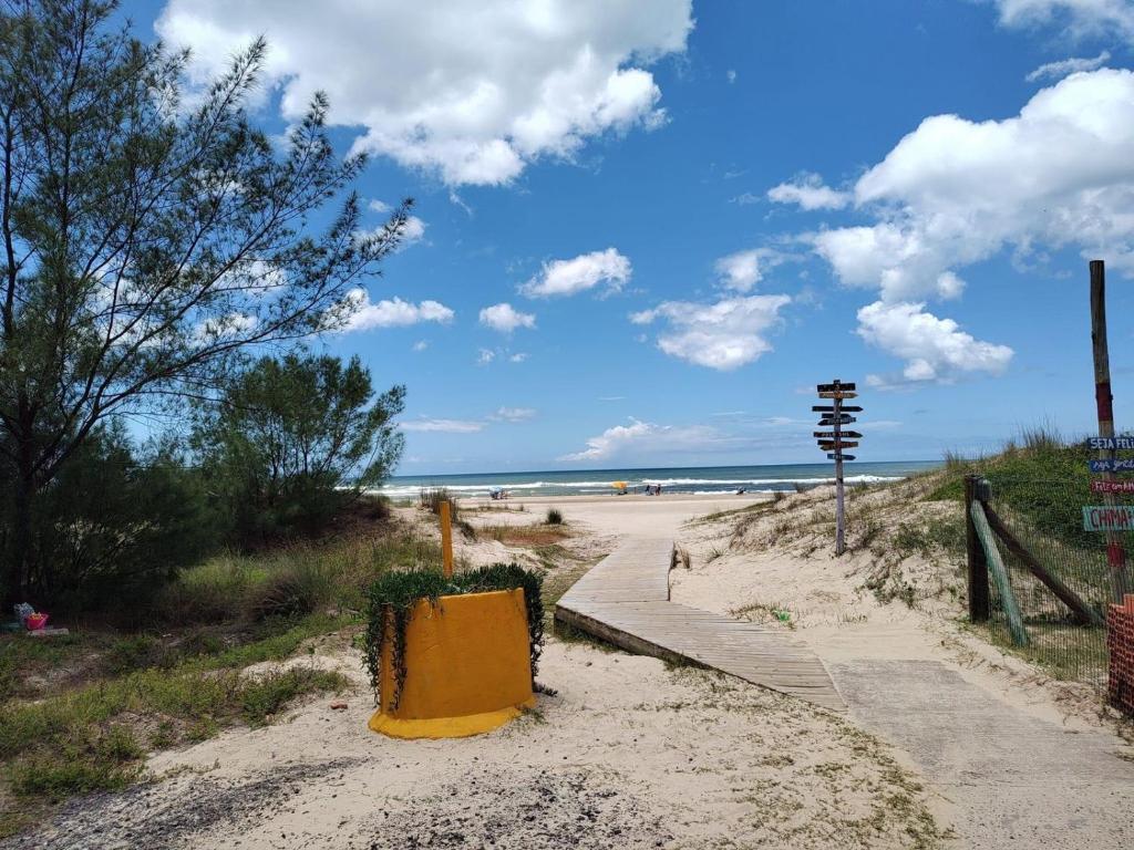 a sandy beach with a path to the beach at Casa pé na areia in Capão da Canoa
