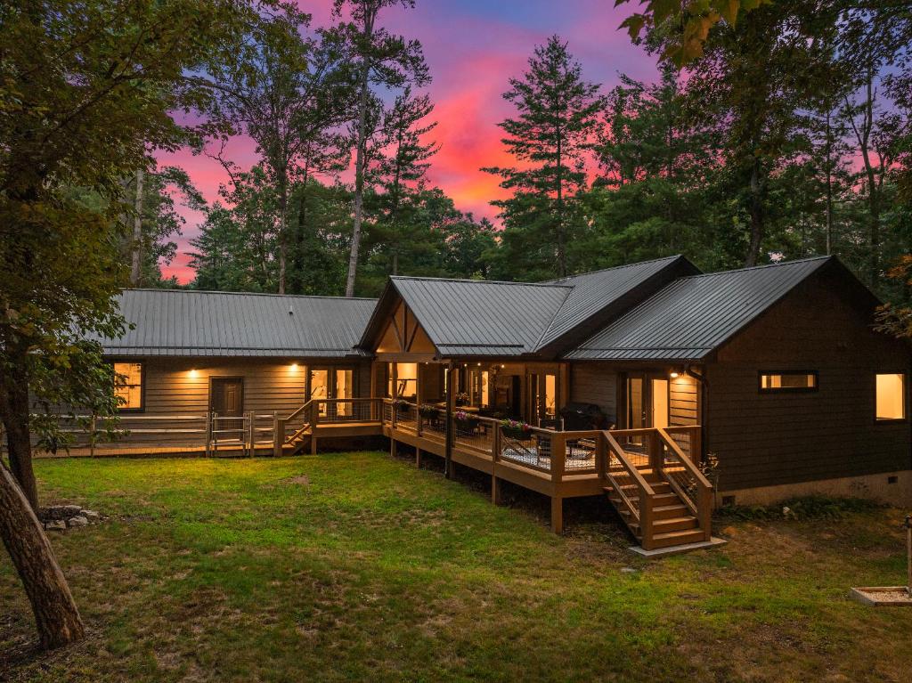 アッシュビルにあるLUXE, 2 miles to Downtown, Hot Tub, Fire Pit, Secluded Serenity of the Blue Ridge Mountainsの夕日の森のログキャビン