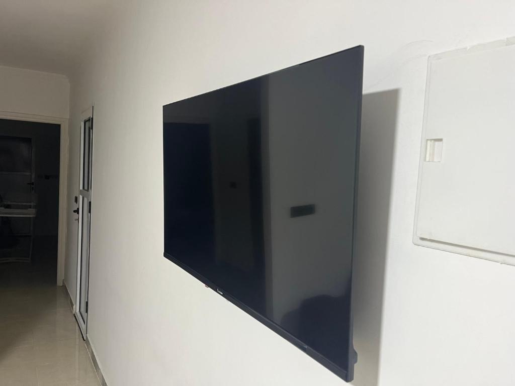 a flat screen tv hanging on a wall at Al hanaa in Monte ʼArrouit