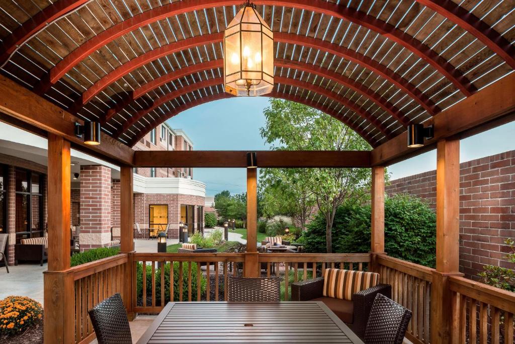 un patio al aire libre con una pérgola de madera con mesa y sillas en Courtyard by Marriott Columbia, en Columbia