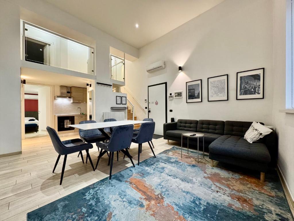 uma sala de estar com um sofá, uma mesa e cadeiras em Future Apartments em Milão