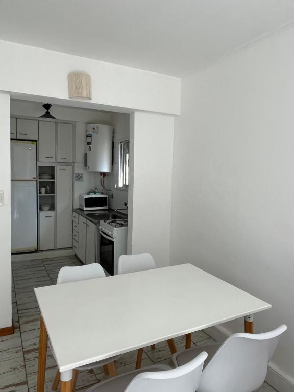 - une cuisine avec une table blanche et des chaises blanches dans l'établissement Departamento en Mar del Plata, Zona La Perla, à Mar del Plata
