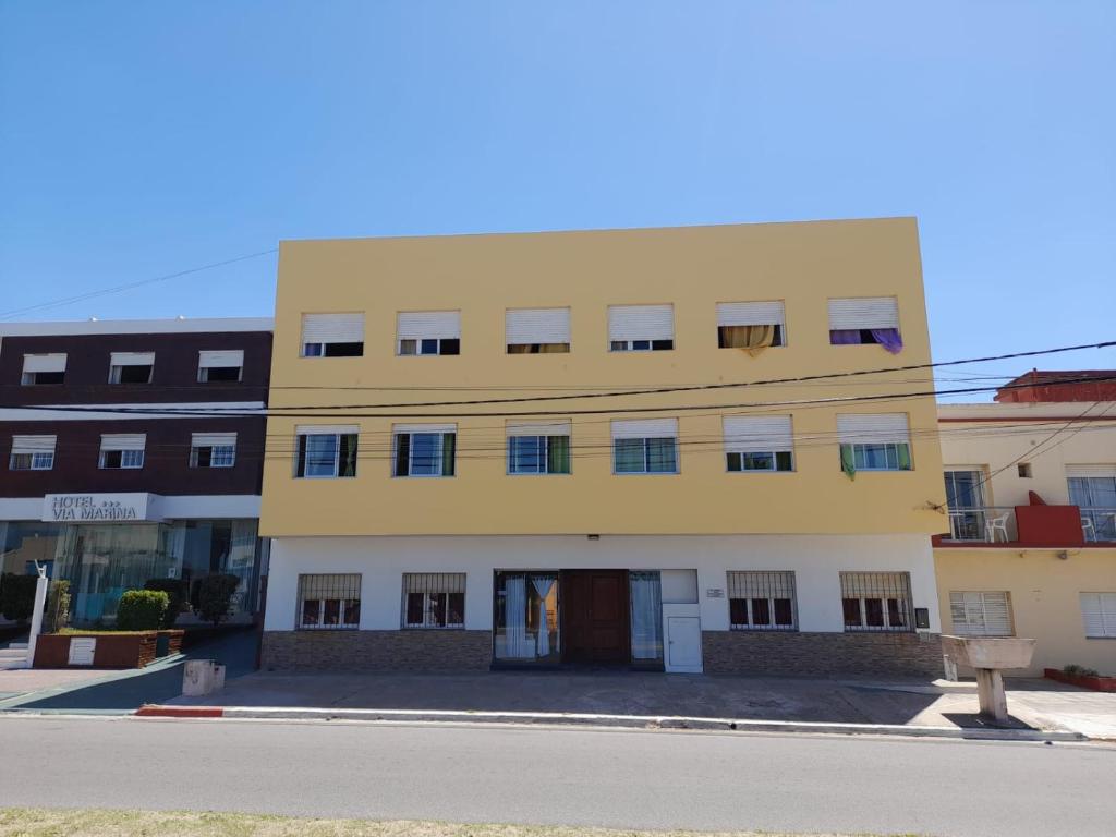 un bâtiment jaune au bord d'une rue dans l'établissement Mutualidad de empleados del Club Gimnasia y Esgrima de Buenos Aires, à Mar de Ajó