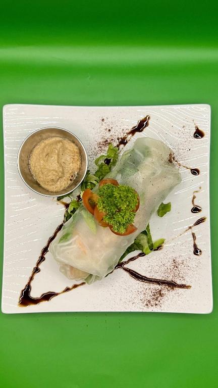 a plate of food with broccoli and a sauce at Akwaba Lodge in The Gap