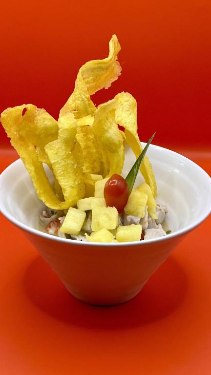 a white bowl filled with chips and a cherry tomato at Akwaba Lodge in The Gap