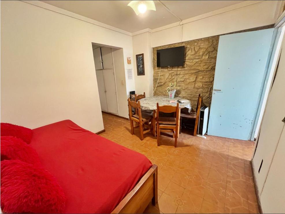 Un dormitorio con una cama, una mesa y un televisor. en Departamento 2 ambientes, en Mar del Plata