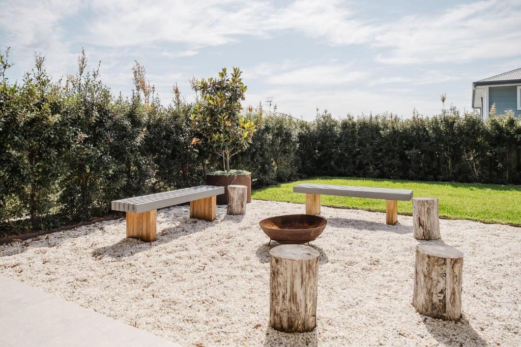 a group of benches sitting on logs in a park at Carinya at Narrawallee in Narrawallee