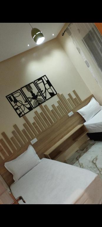 a bedroom with two beds and a sign on the wall at Appartement meublé in Meknès