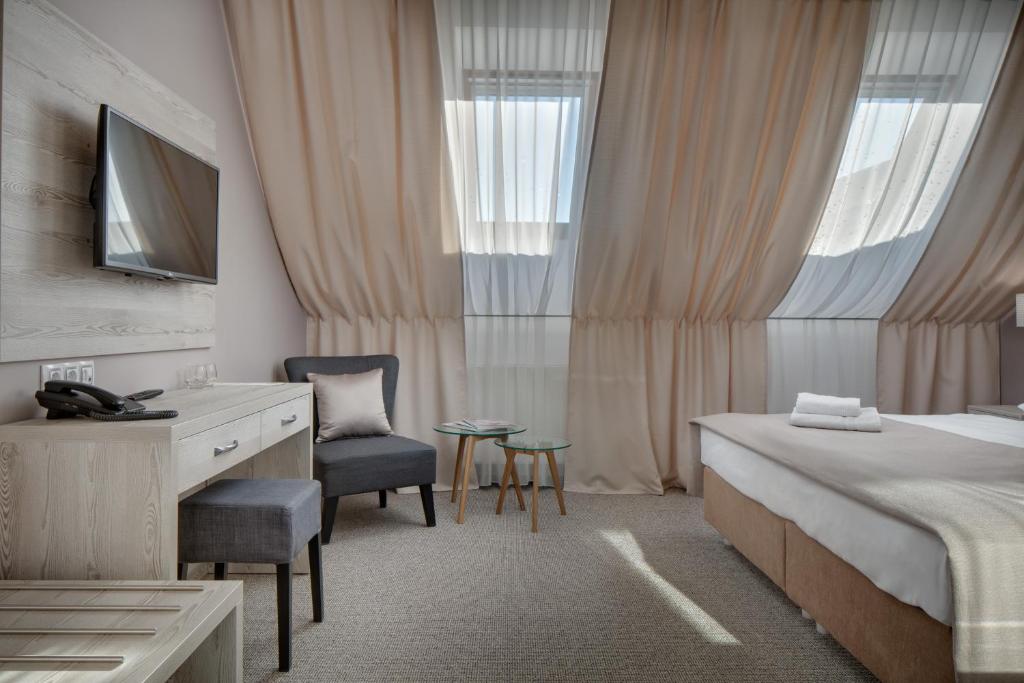 a bedroom with a bed and a desk and a chair at Hotel Florenc in Prague