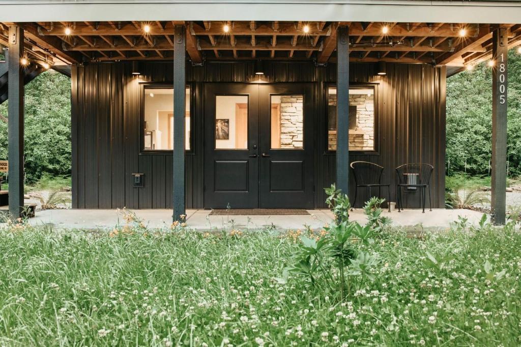 ein Haus mit schwarzer Tür und ein paar Blumen in der Unterkunft Ensuite 08 - A Newly Remodeled Studio - A Perfect Romantic Getaway in Deming