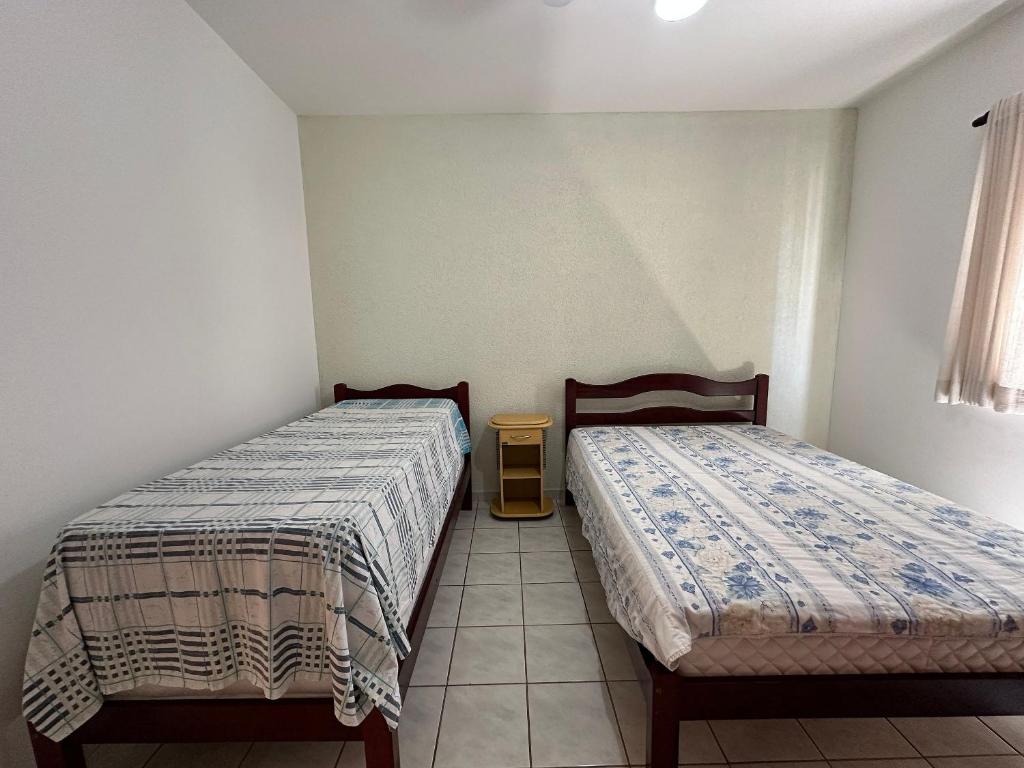 1 Schlafzimmer mit 2 Betten und Fliesenboden in der Unterkunft Apto Próx. ao Mar na Guilhermina - Melhor Local in Praia Grande