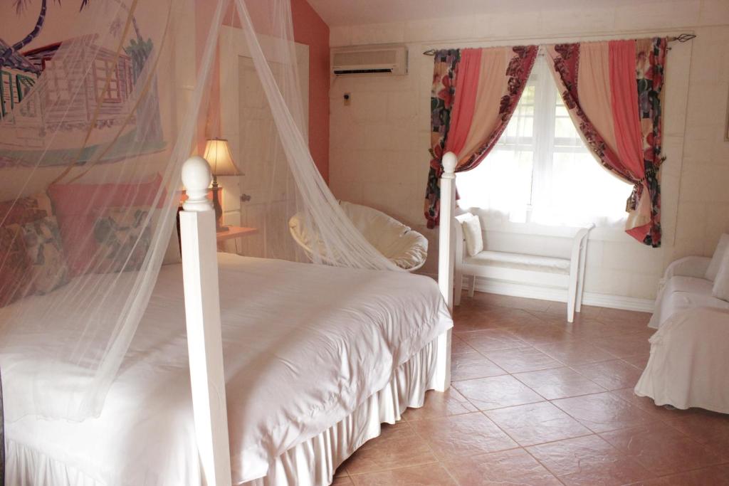a bedroom with a bed with a mosquito net at The Legend Garden Condos in Saint Peter