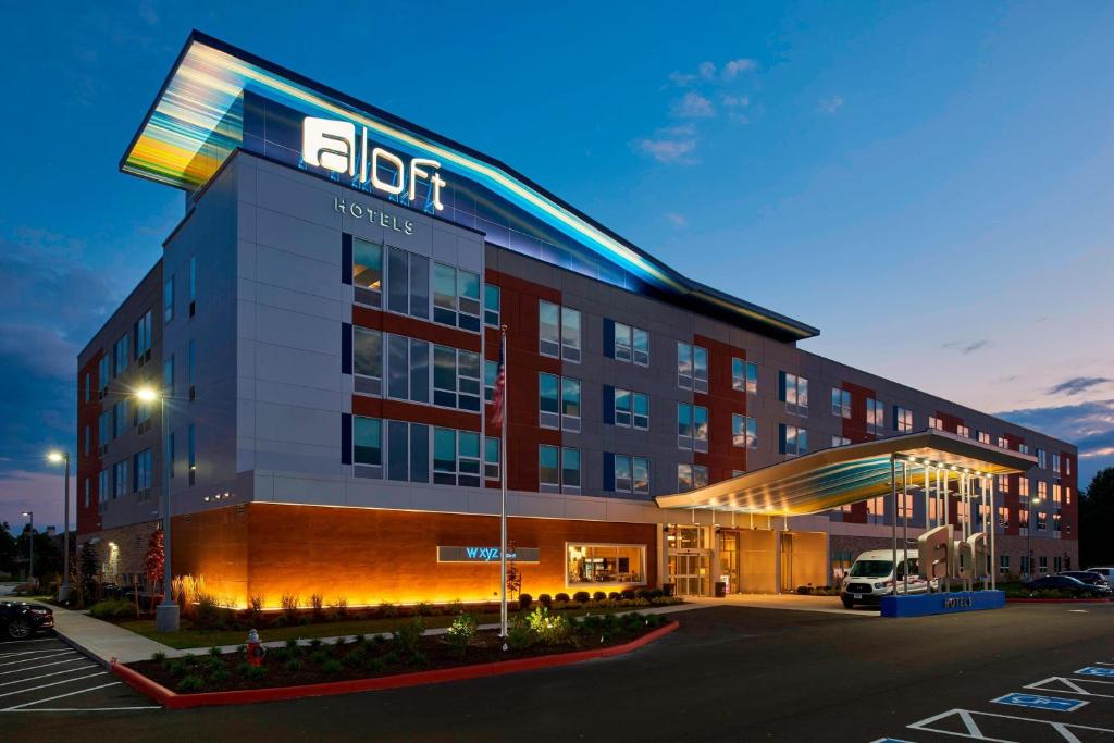un hôtel avec un panneau sur le côté d'un bâtiment dans l'établissement Aloft Cleveland Airport, à North Olmsted