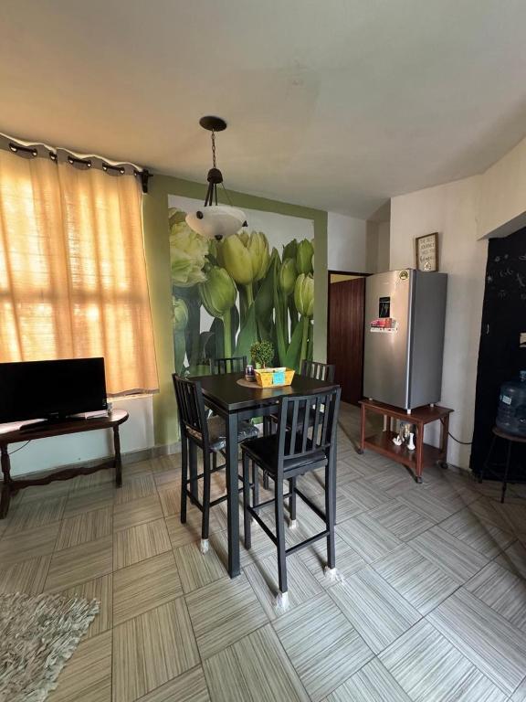 a living room with a table and chairs and a refrigerator at Casa a pasos de la Laguna del Carpintero in Tampico