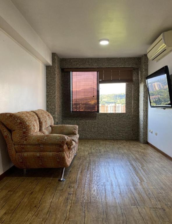 a living room with a couch and a flat screen tv at Alojamiento en Valencia in Naguanagua