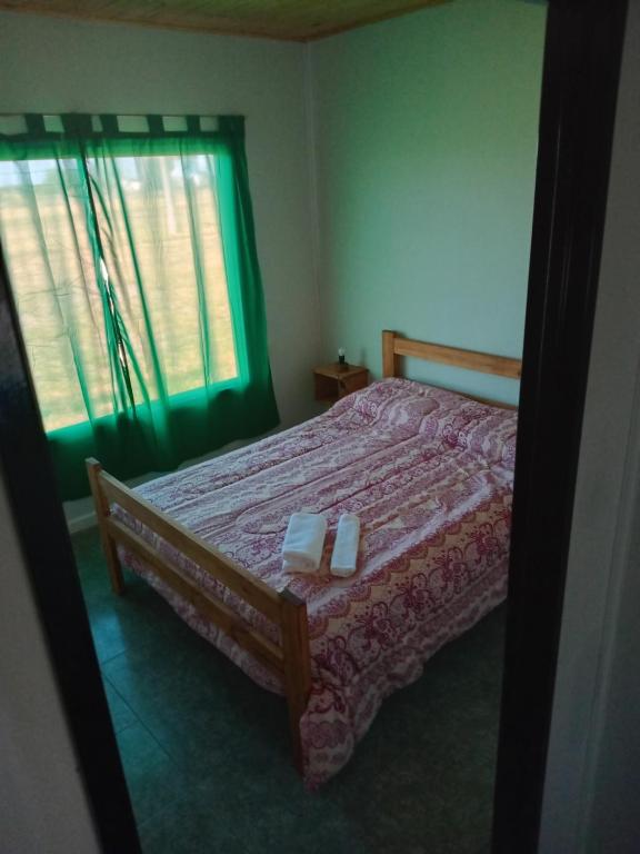 Un dormitorio con una cama con dos velas encima. en Cabañas Emilia, en La Adela