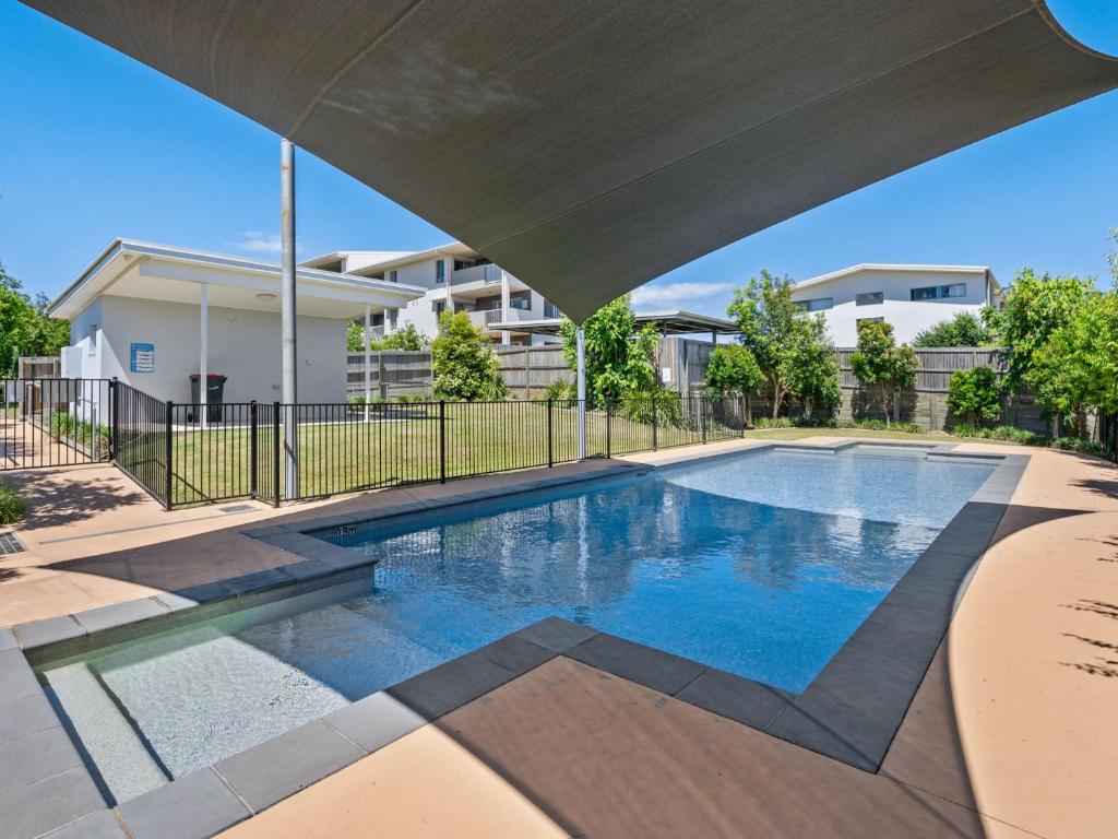 Una piscina en un patio con un edificio. en Homely & Welcoming in Mango Hill, en North Lakes