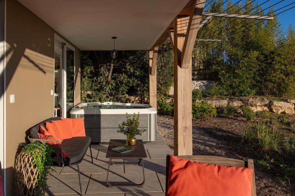 d'une terrasse avec un bain à remous et deux chaises. dans l'établissement 2 Pièces terrasse Jacuzzi privatif dans villa à 5 minutes de Sophia Antipolis, à Valbonne