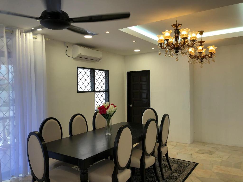 a dining room with a black table and chairs at Anjung Villa in Kuala Terengganu