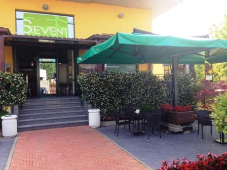 a building with a green umbrella and tables and chairs at Residenza S.Event B&B in Buccinasco