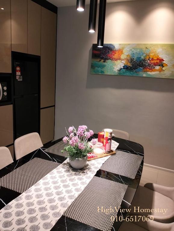 a dining room table with a vase of flowers on it at HighView Homestay in Bandar Baru Bangi