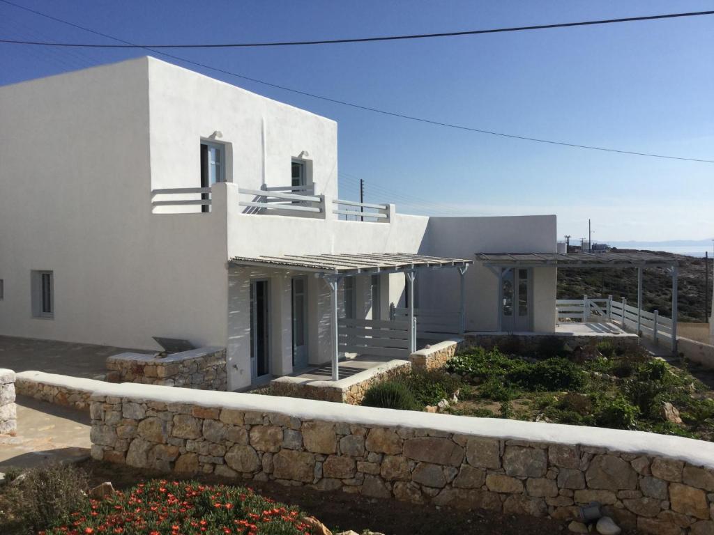 Casa blanca con pared de piedra en Makares, en Donoussa