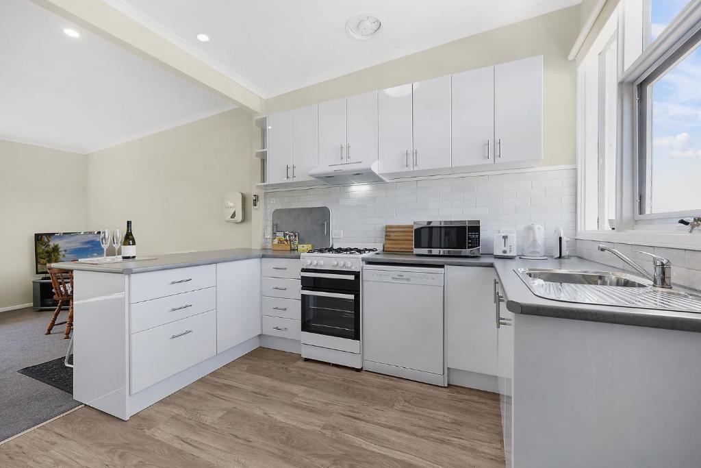 Eine weiße Küche mit weißen Schränken und einer Spüle in der Unterkunft North View in Warrnambool