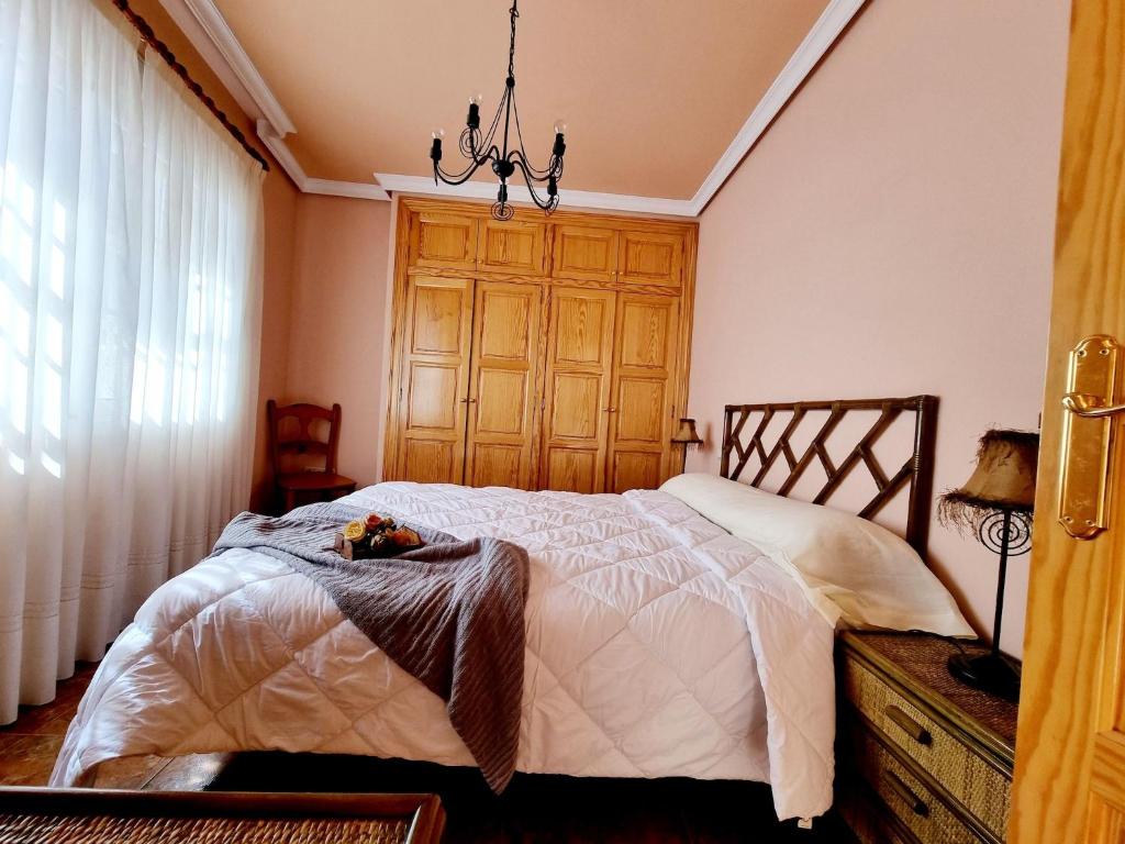 een slaapkamer met een bed en een kroonluchter bij Beachfront Bungalow In La Mata, Torrevieja in Torrevieja