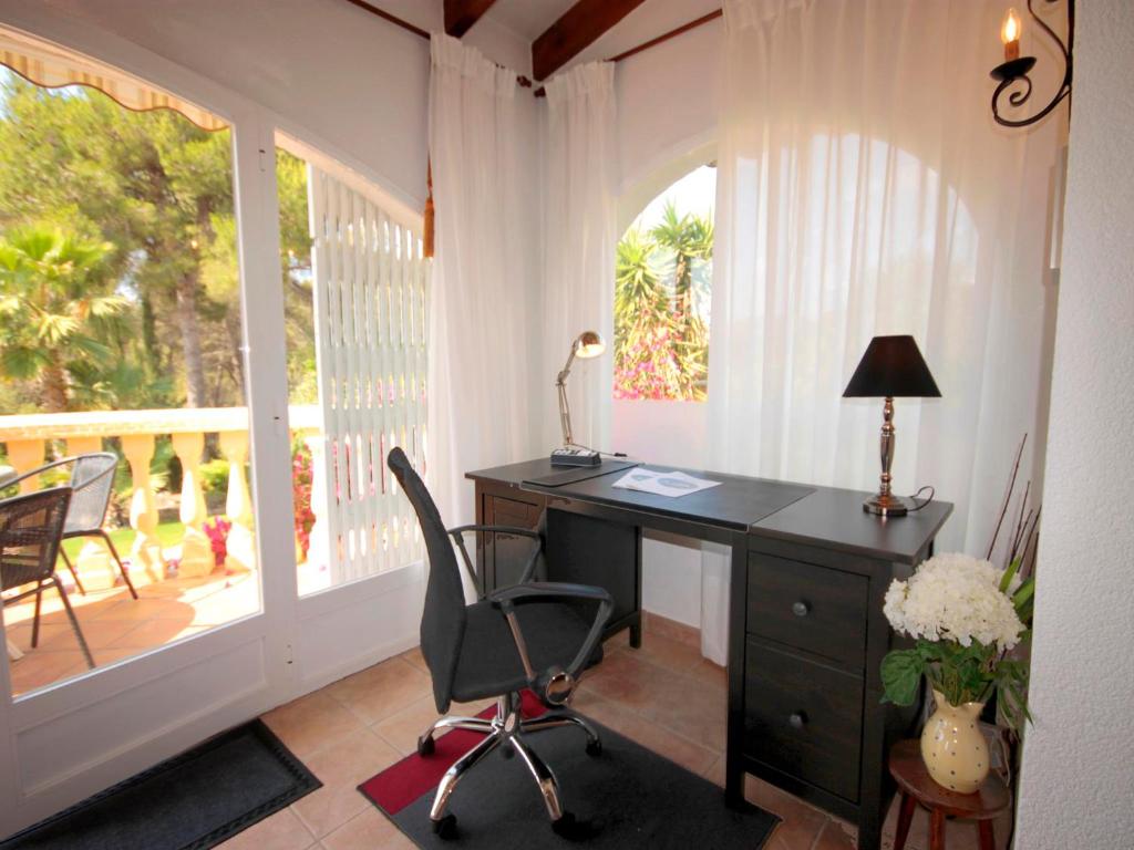 an office with a desk and a chair and a balcony at Villa Amaya in Jávea