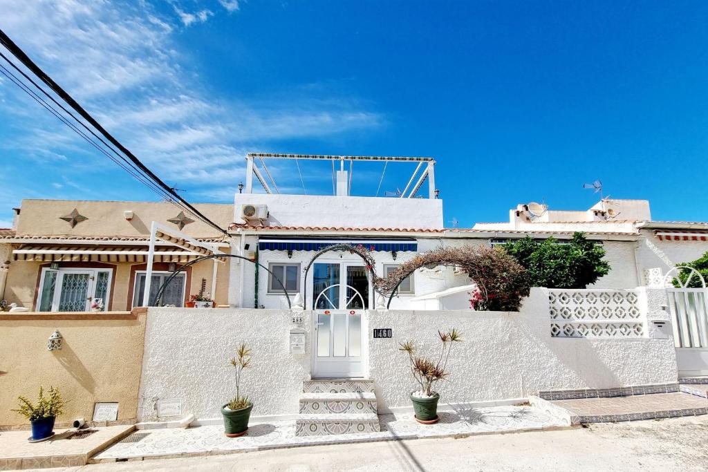 a white house with a white door and a fence at Bungalow near the Salt Lakes of Torrevieja and La Mata and their beaches in La Mata