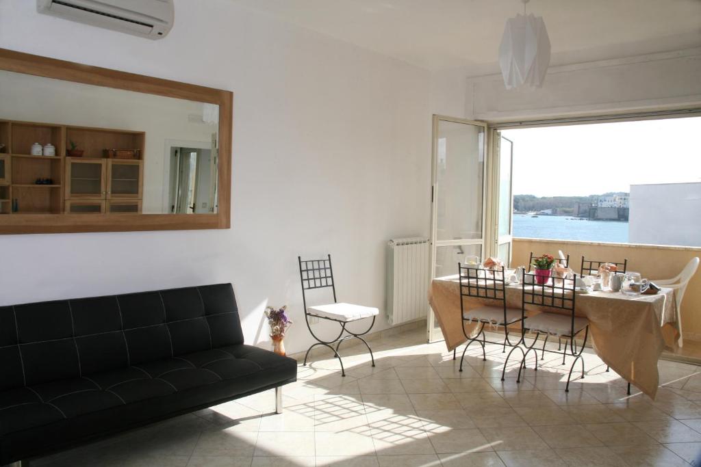 - un salon avec un canapé et une table avec des chaises dans l'établissement B&B Gelsimori, à Otrante