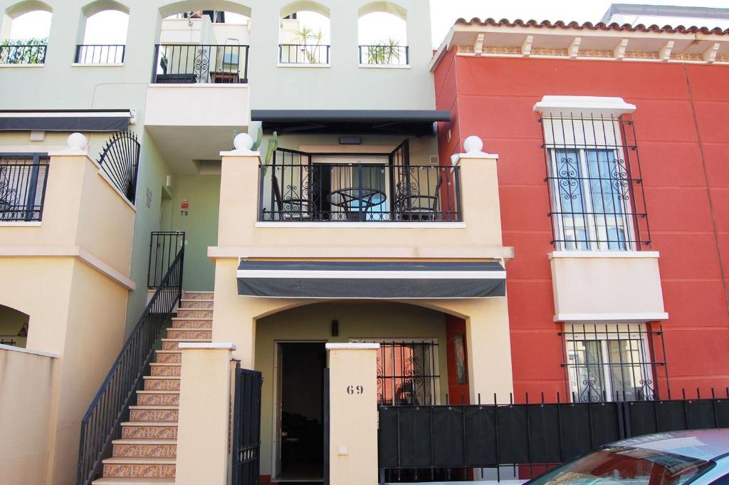 ein rot-weißes Gebäude mit einer Tür in der Unterkunft Retreat Near the Sea Av La Mancha Aguas Nuevas in Torrevieja