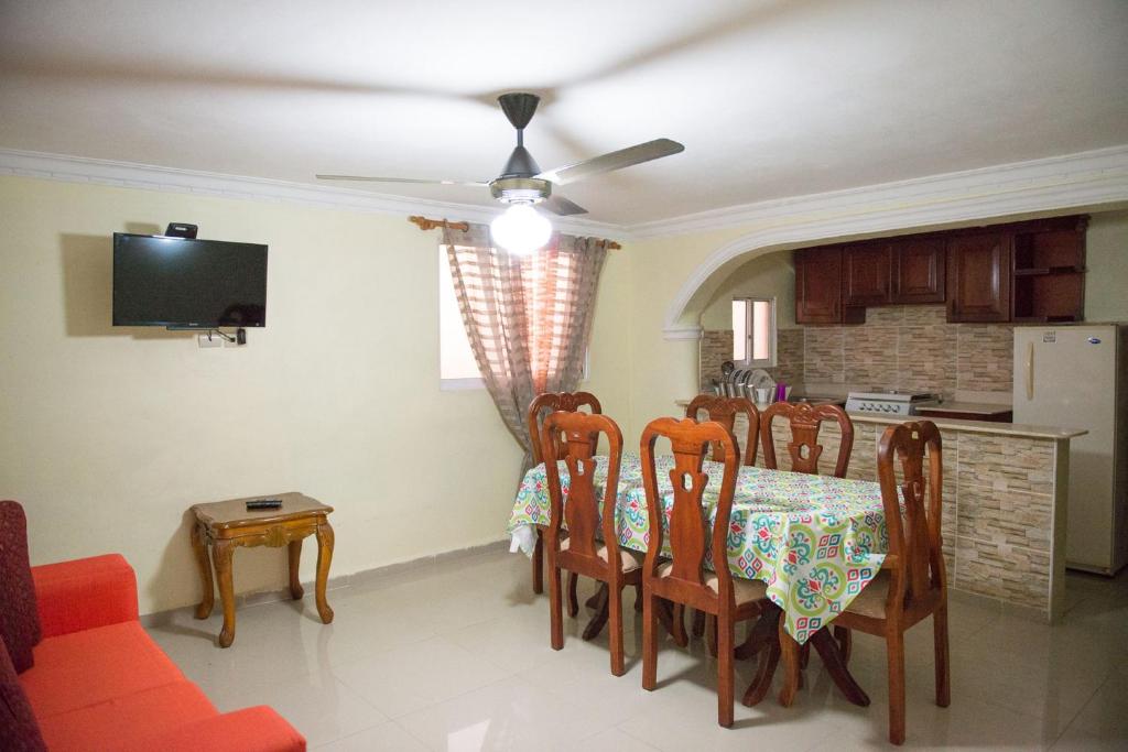 ein Esszimmer mit Tisch und Stühlen und einem Fernseher in der Unterkunft 2 Bedroom 2 Bathroom Apartment in Corales del Sur - Parque del Este - Airport in La Viva