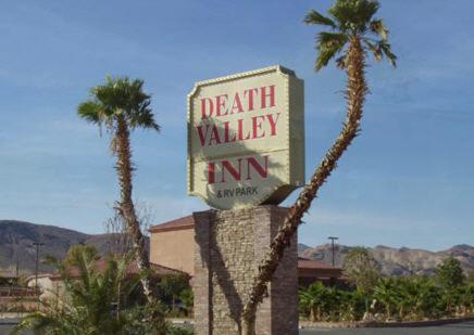 a sign that is on top of a tree at Death Valley Inn & RV Park in Beatty