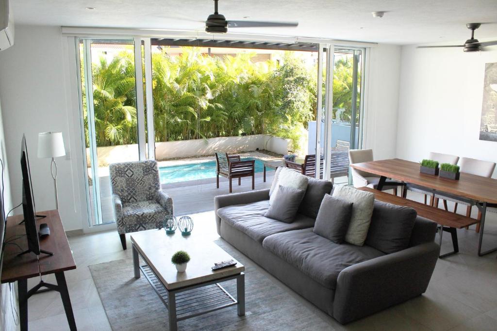 a living room with a couch and a table at New Villa 207 Deluxe , Golf Club, Punta Cala in Nuevo Vallarta 