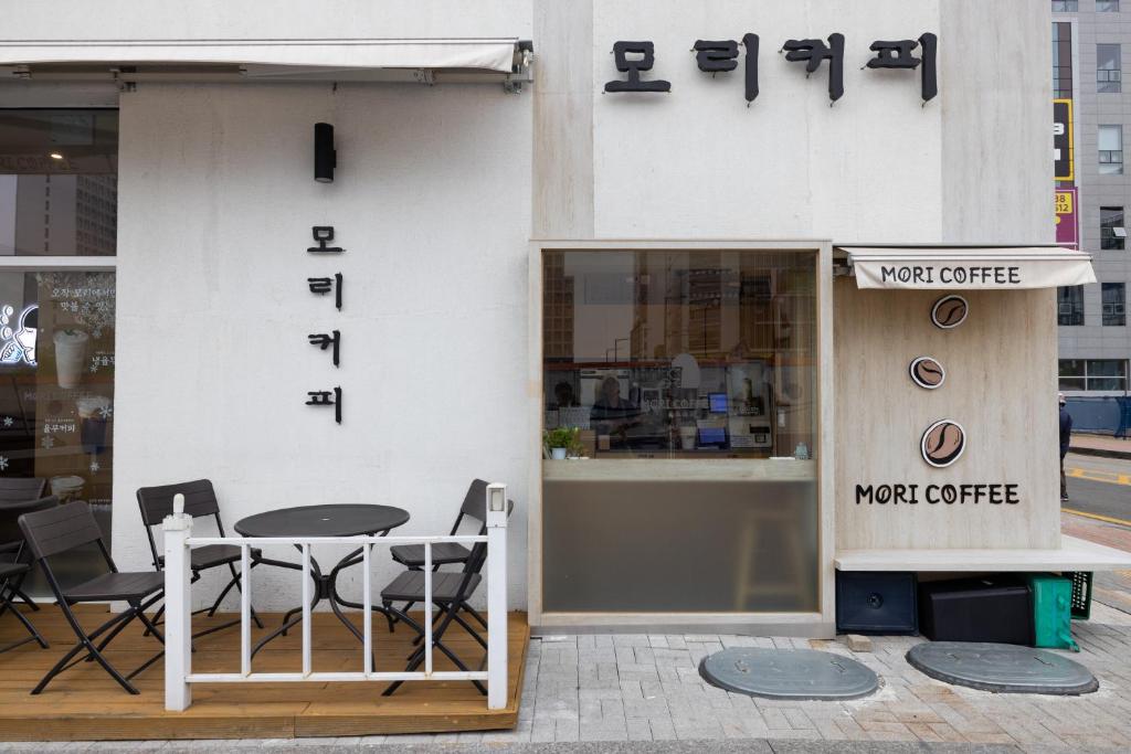 a cafe with a table and chairs on the side of a building at Grand Bleu Hotel & Residence in Incheon