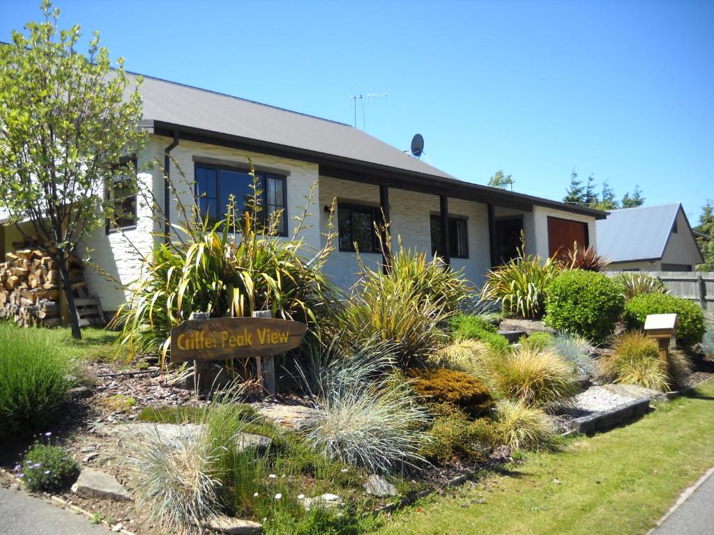 une maison avec un panneau dans la cour avant dans l'établissement Criffel Peak View Bed and Breakfast, à Wanaka
