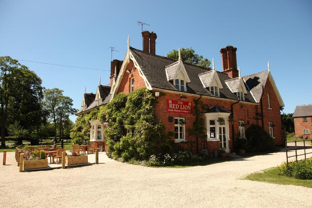 an old brick building with a red sign on it at The Red Lion in Revesby