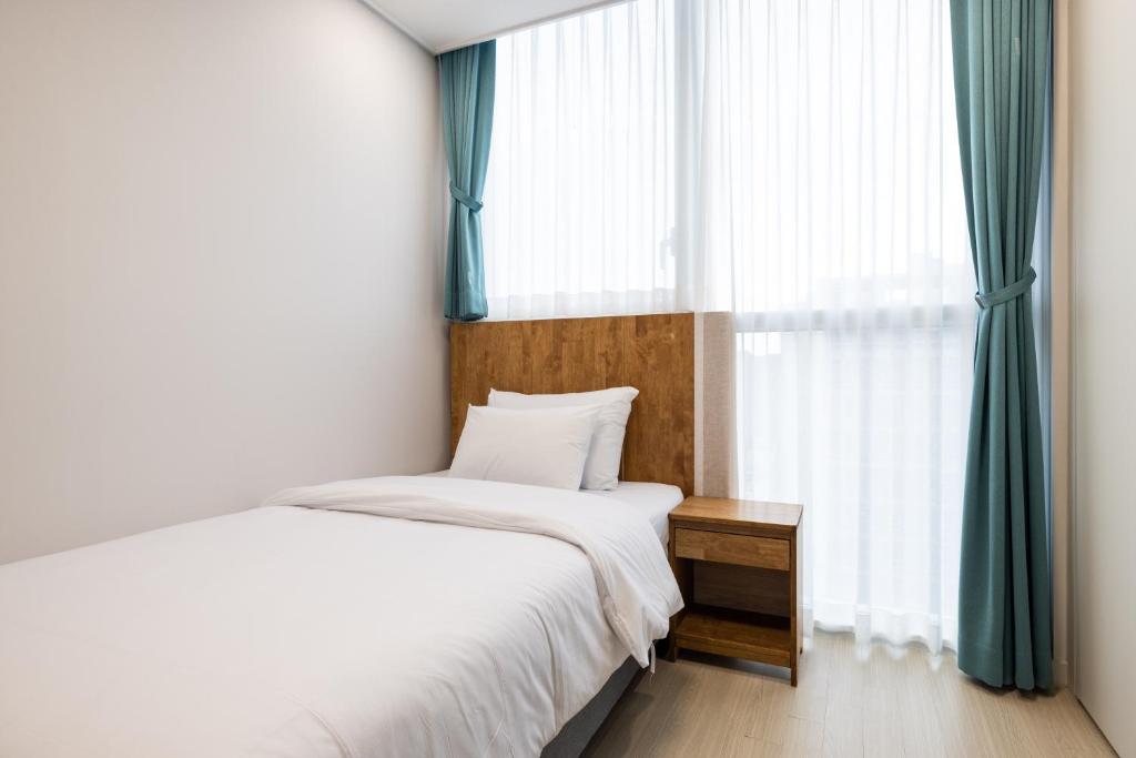 a bedroom with a bed and a large window at Grand Bleu Hotel & Residence in Incheon