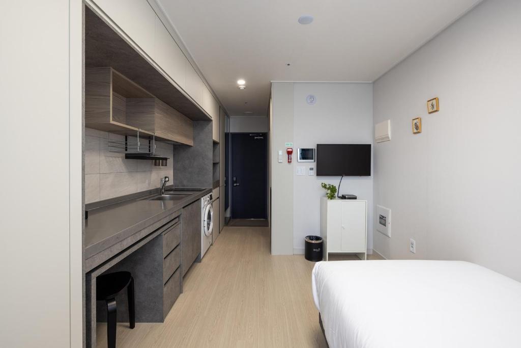 a bedroom with a bed and a sink and a kitchen at Grand Bleu Hotel & Residence in Incheon