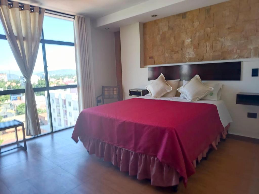a bedroom with a large bed and a large window at Departamento Independencia in Tarija