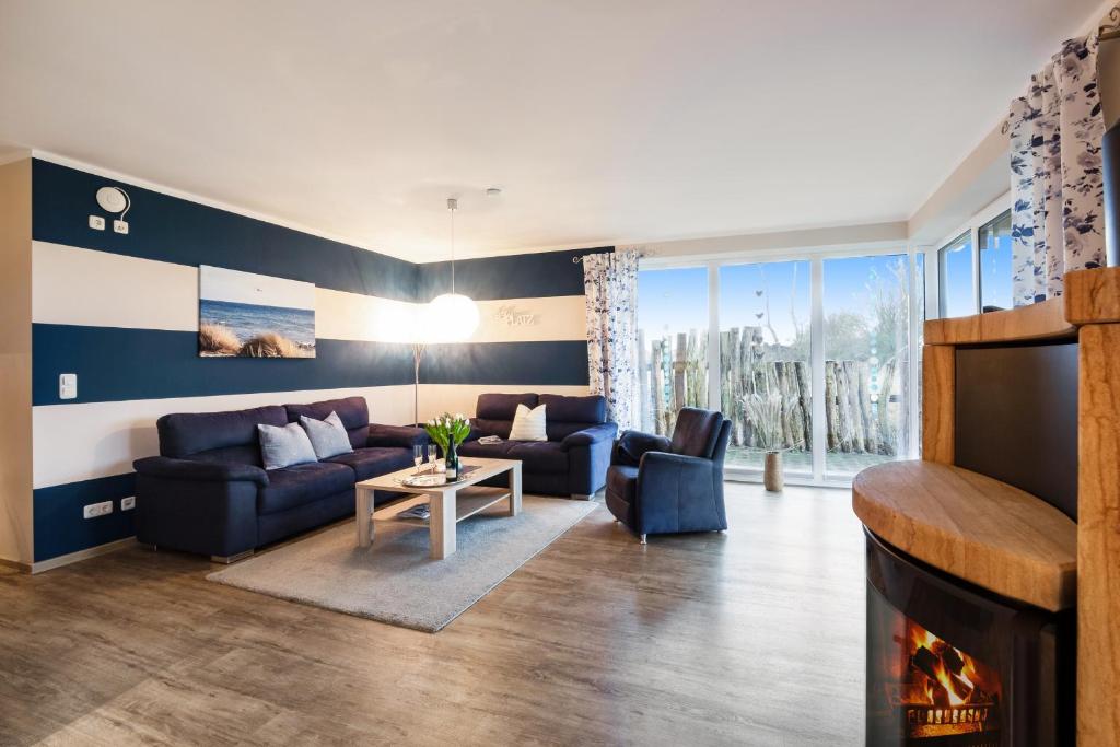 a living room with a couch and a fireplace at Wellnes Bungalow Sanddüne in Fehmarn
